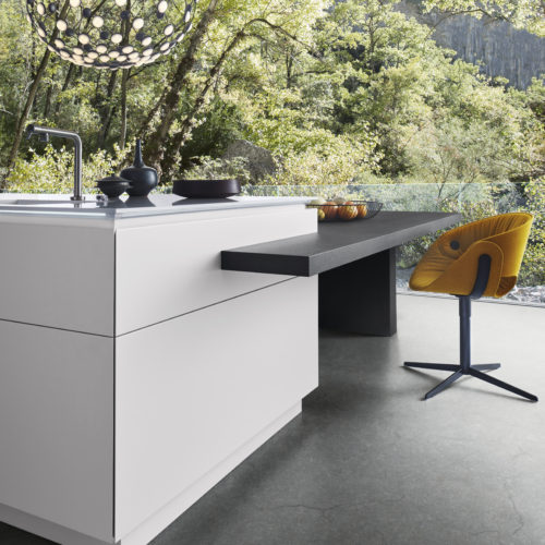 alt="Close up corner view of kitchen island in CLASSIC-FS white matte-lacquer with TOPOS oak table extension"