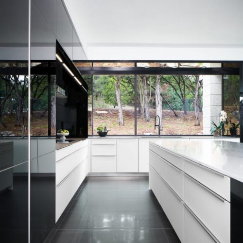 alt="Interior kitchen view of matte white glass lowers and black gloss IOS glass talls"