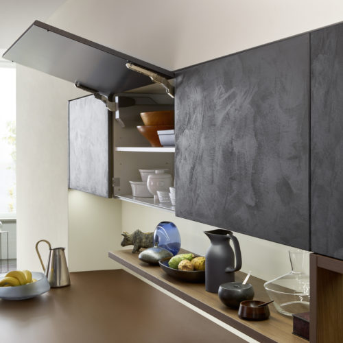alt="Push to open upper cabinet with dark concrete finish and motorized hinge"