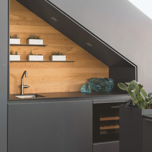 alt="Full view of bar nook with carbon gray matte satin lacquer cabinets"