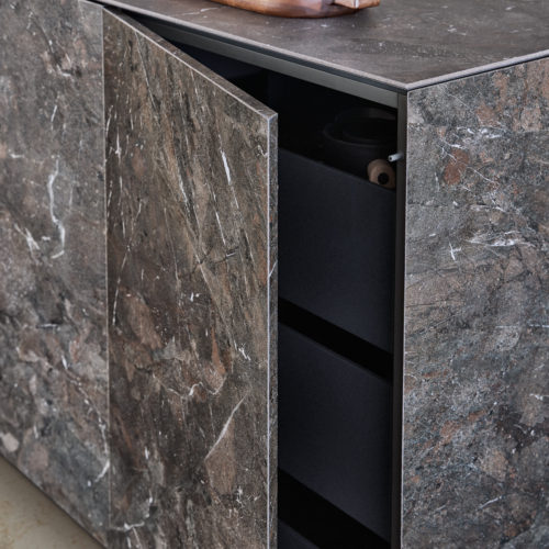 alt="close up corner view of worktop in NASCA with open cabinet showing pull outs"