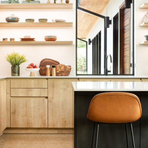 alt="Side view of kitchen corner with karst oak handle-less cabinets and open shelving"