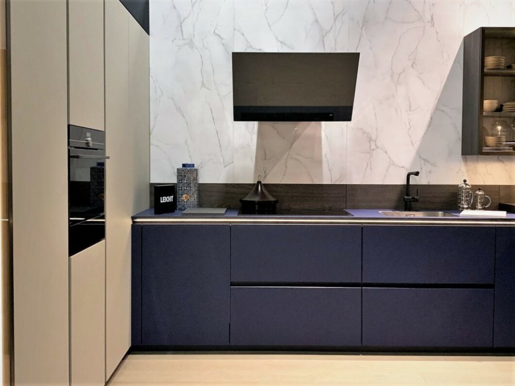 alt="Left focus view of the midnight blue fonts, olive grey paneling on closed unit with oven, and range with TOPOS bergamo elm"