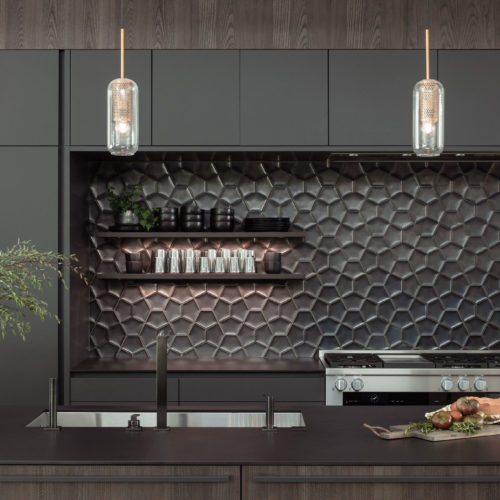 alt="close up of stove top showing floating shelves with integrated lighting, tall, upper, and lower cabinets and drawers in carbon gray matter satin lacquer"