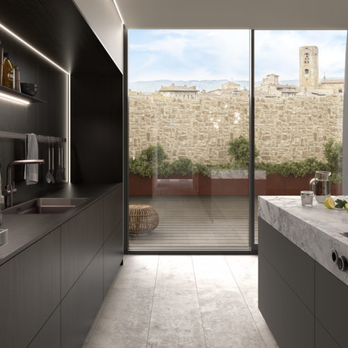 alt="Courtyard facing view with oak selva wall paneling on the left and the kitchen island with fossil gray handleless drawers and ROCCA top on the right"