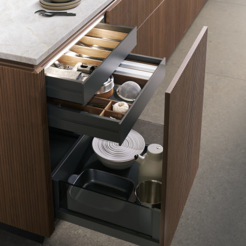 alt=”Close up of island interior system showing wood finishes and item organization”