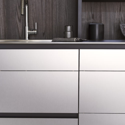 alt="frontal view of island showing sink, elm paneling, and aluminum coated, matte lacquered kitchen front"